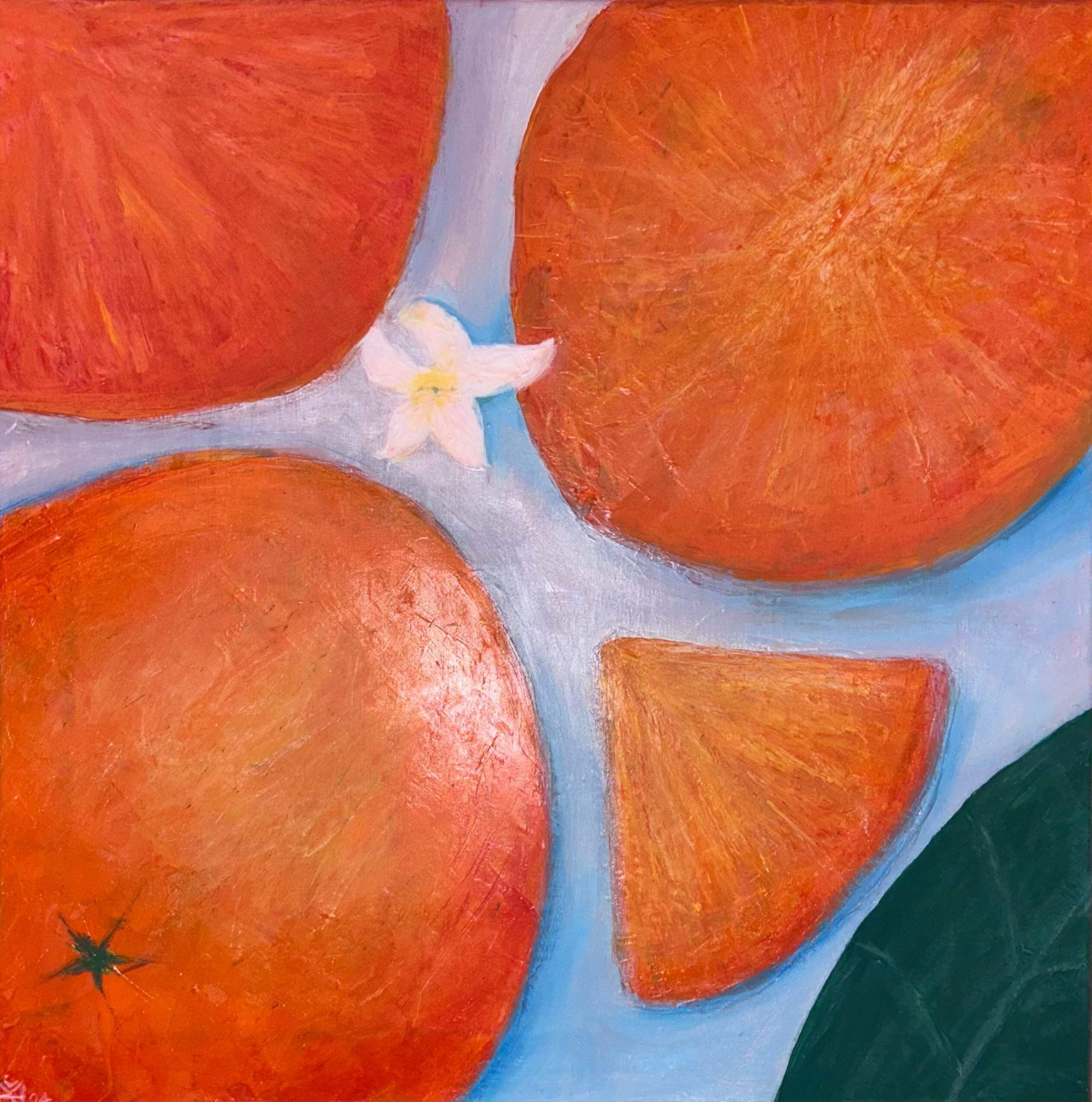 oranges on a blue table, leaf in bottom left corner